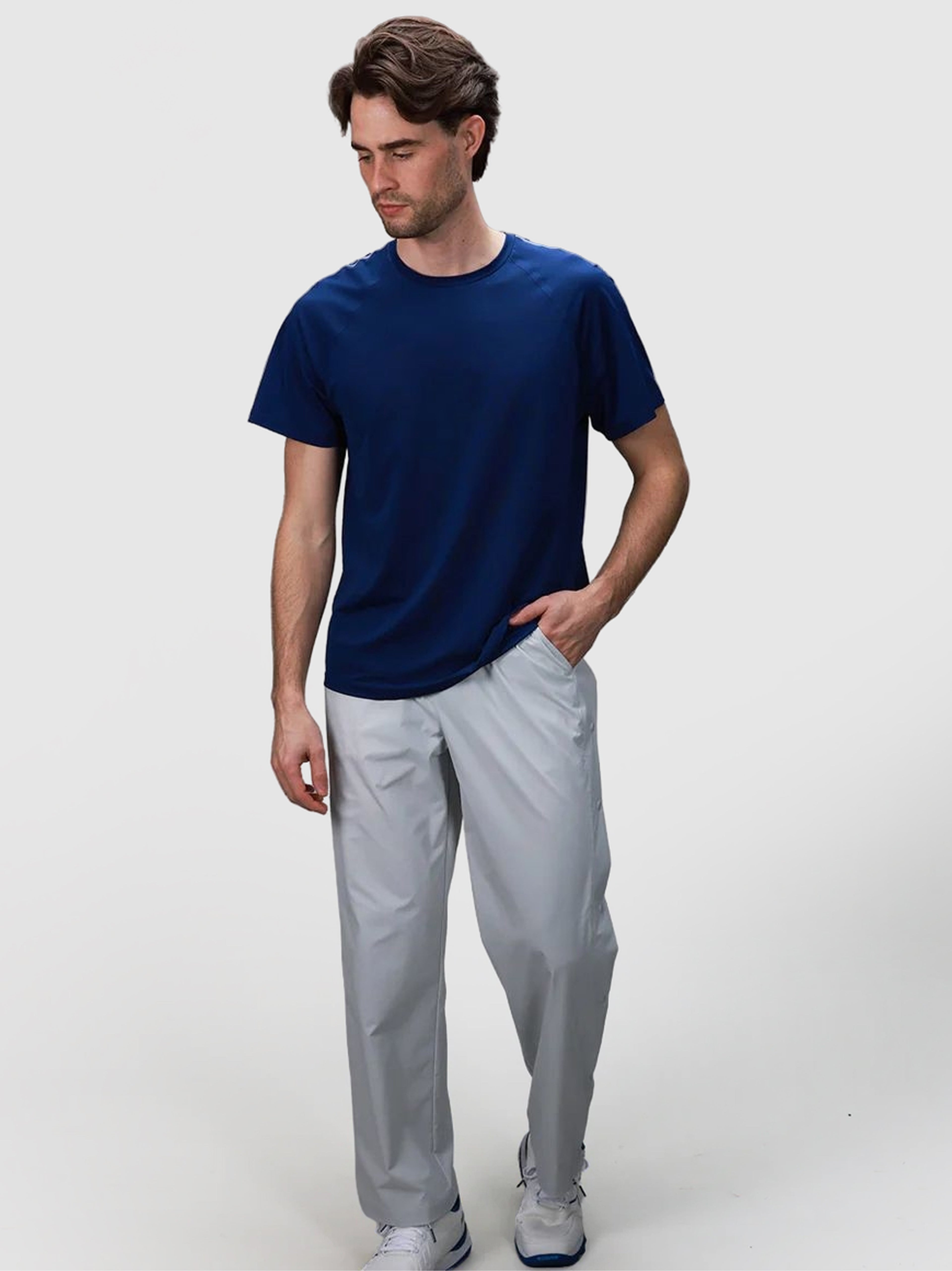 Man wearing gray J Sas Tear Away Pant by MUEV paired with navy shirt, designed for pickleball and padel apparel
