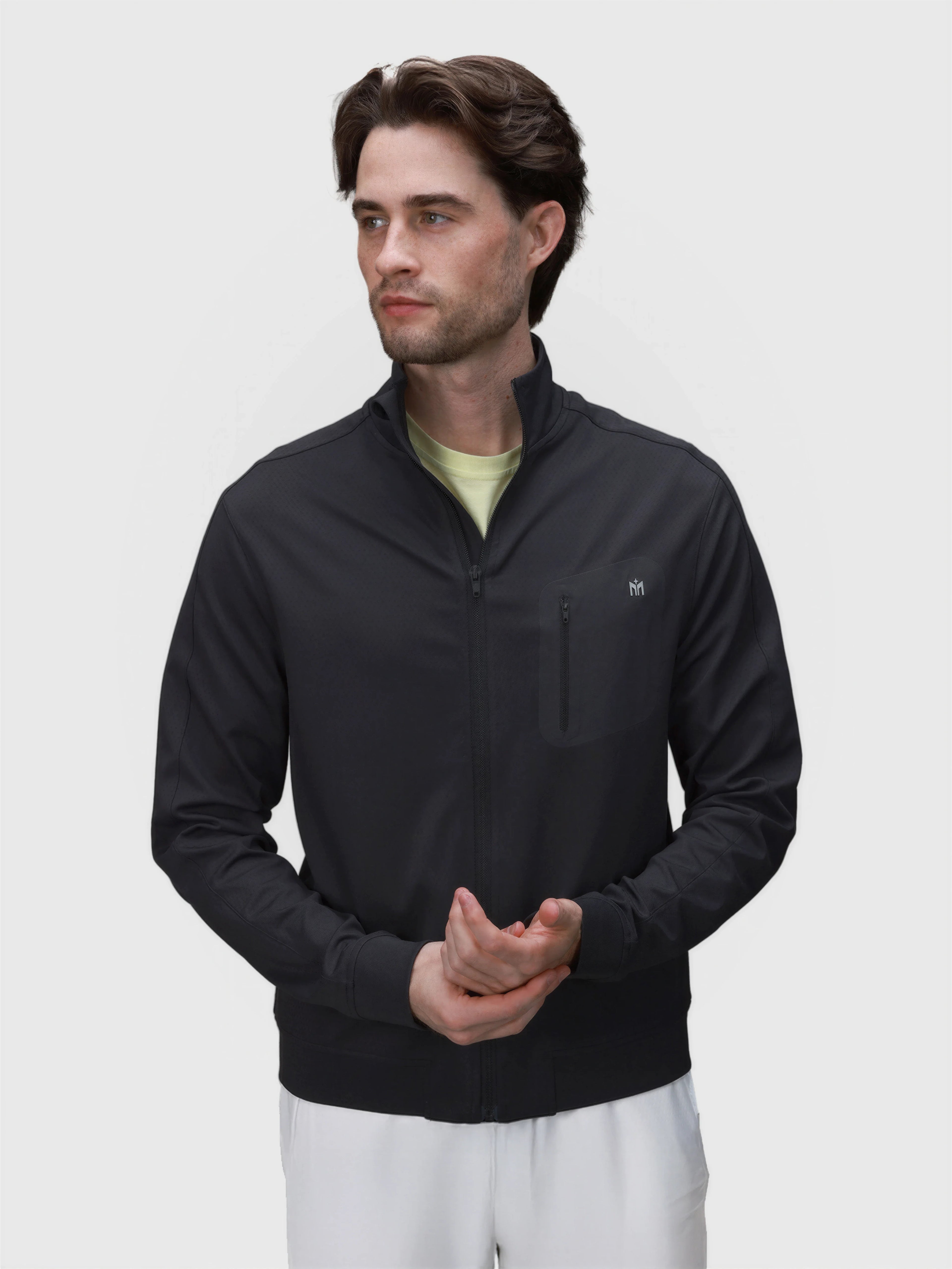 Man wearing black Echelon Jacket with zippered chest pocket in pickleball clothing by MUEV