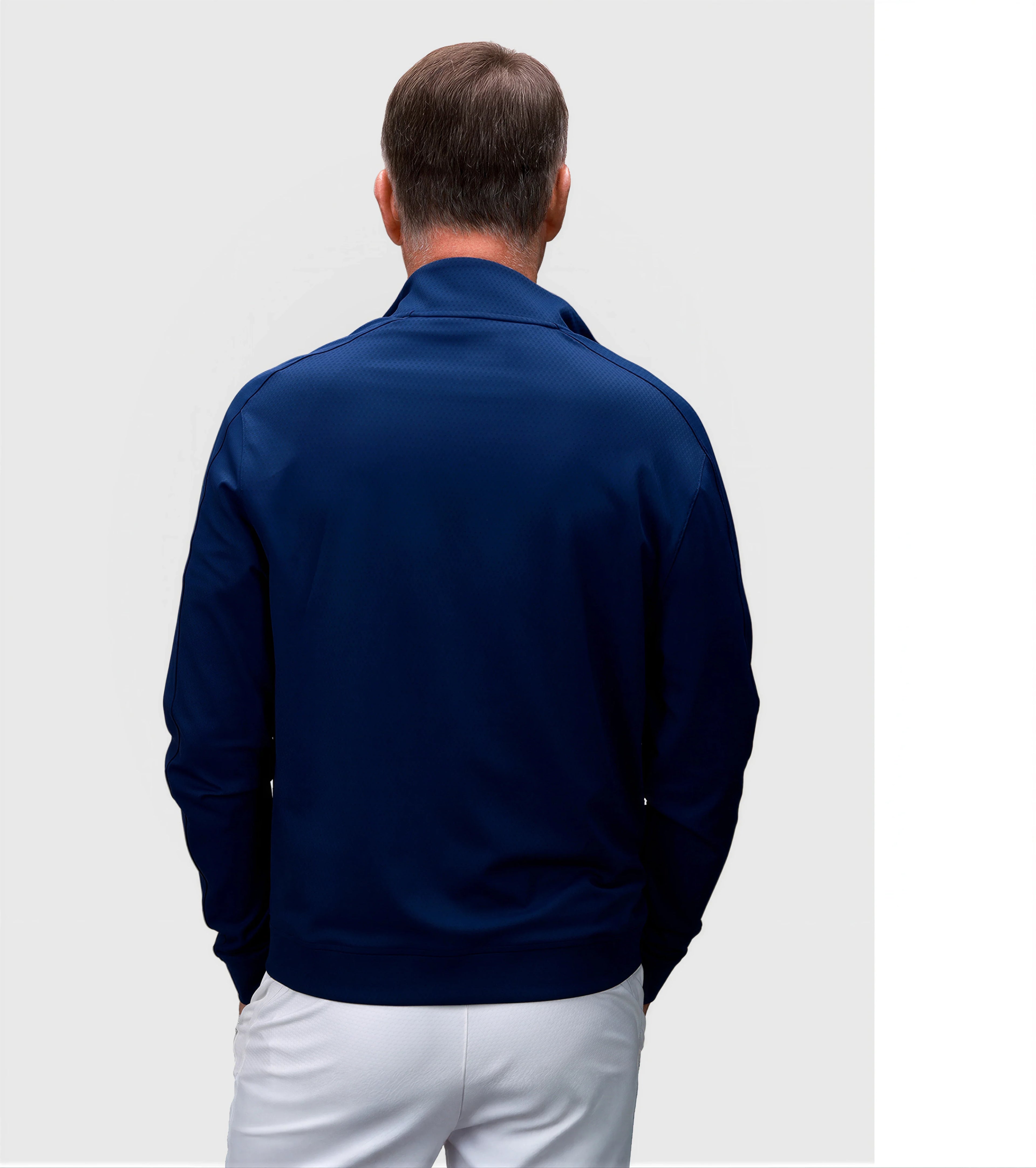 Back view of man wearing Medieval Blue Echelon Jacket in pickleball apparel by MUEV