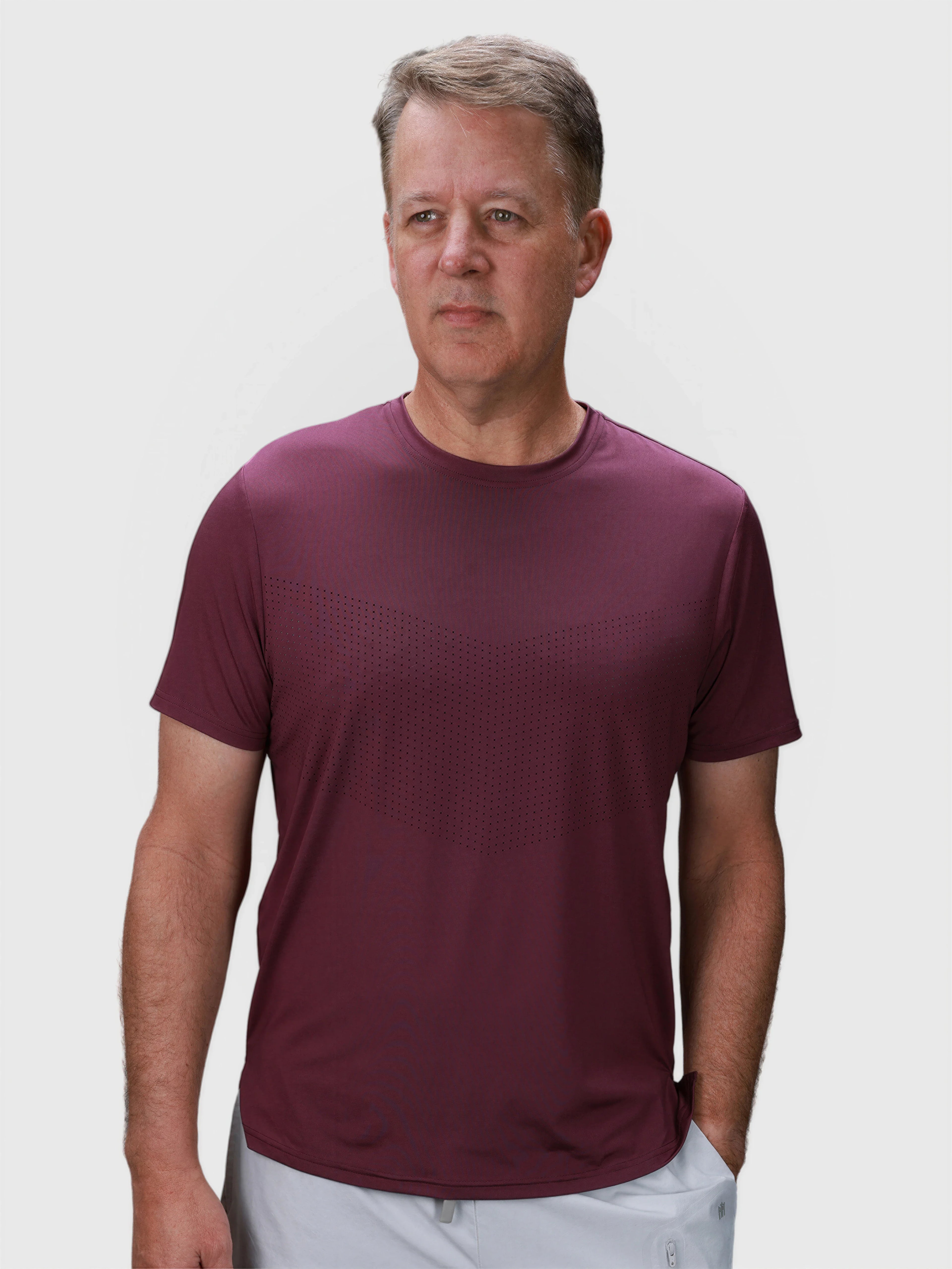 Man wearing plum Chevron Tee by MUEV designed for padel and pickleball apparel with subtle perforated pattern