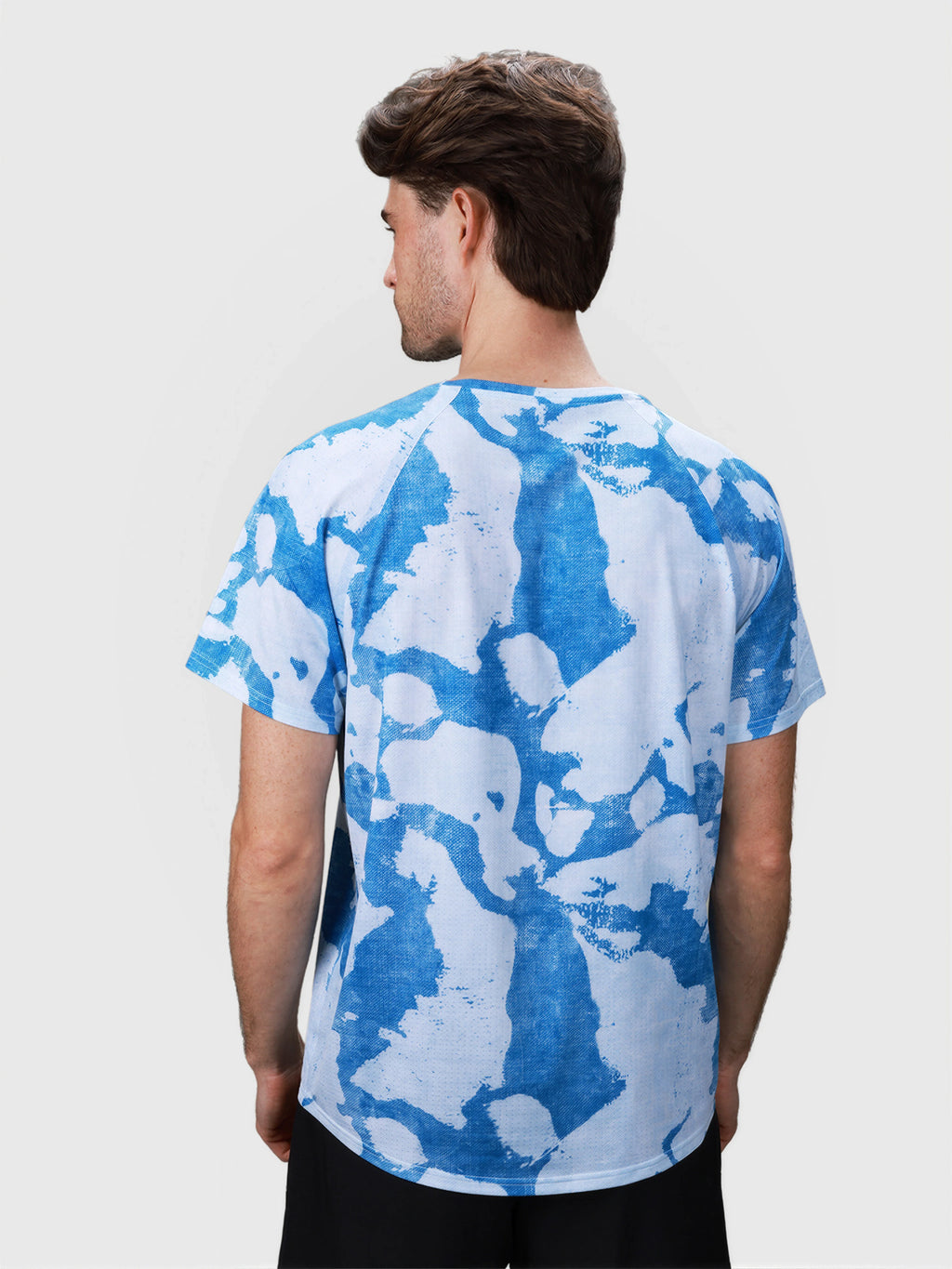 Rear view of man wearing blue and white Digital Camo Dink Performance Tee in pickleball apparel by MUEV