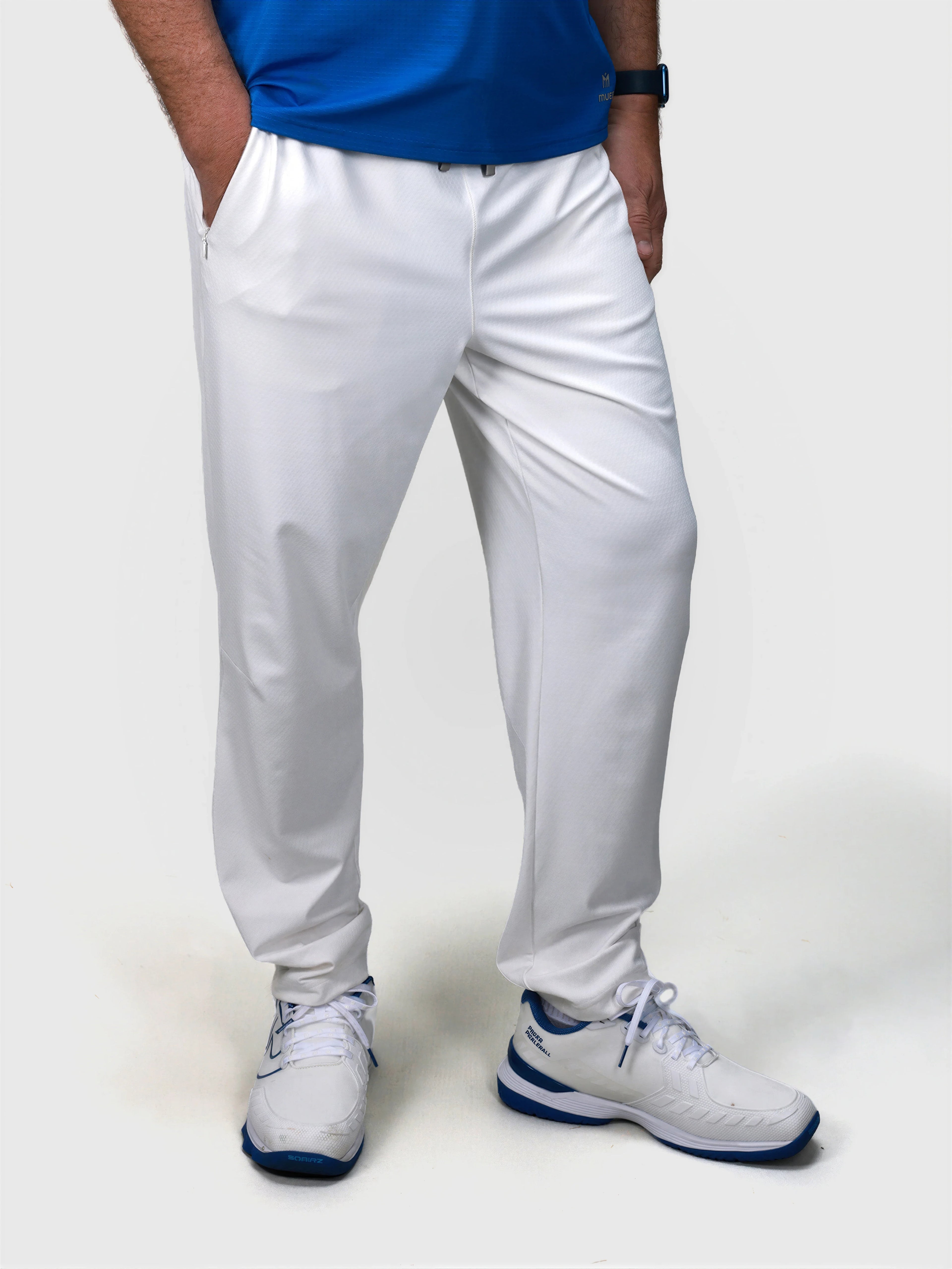 Man wearing white Echelon Jogger by MUEV designed for padel and pickleball apparel with side pockets