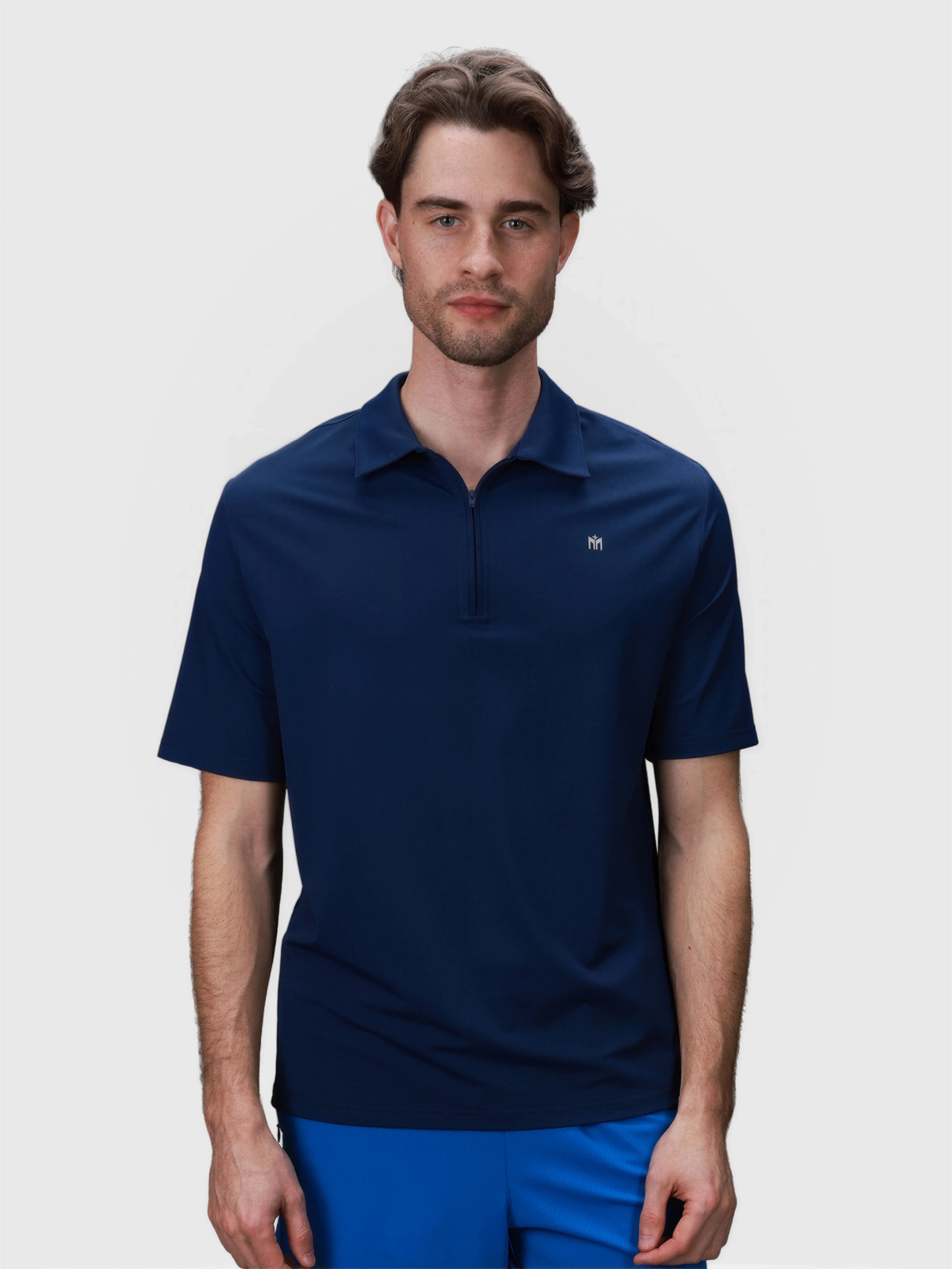 Man wearing medieval blue Elevate Zip Polo by MUEV designed for breathable padel and pickleball apparel