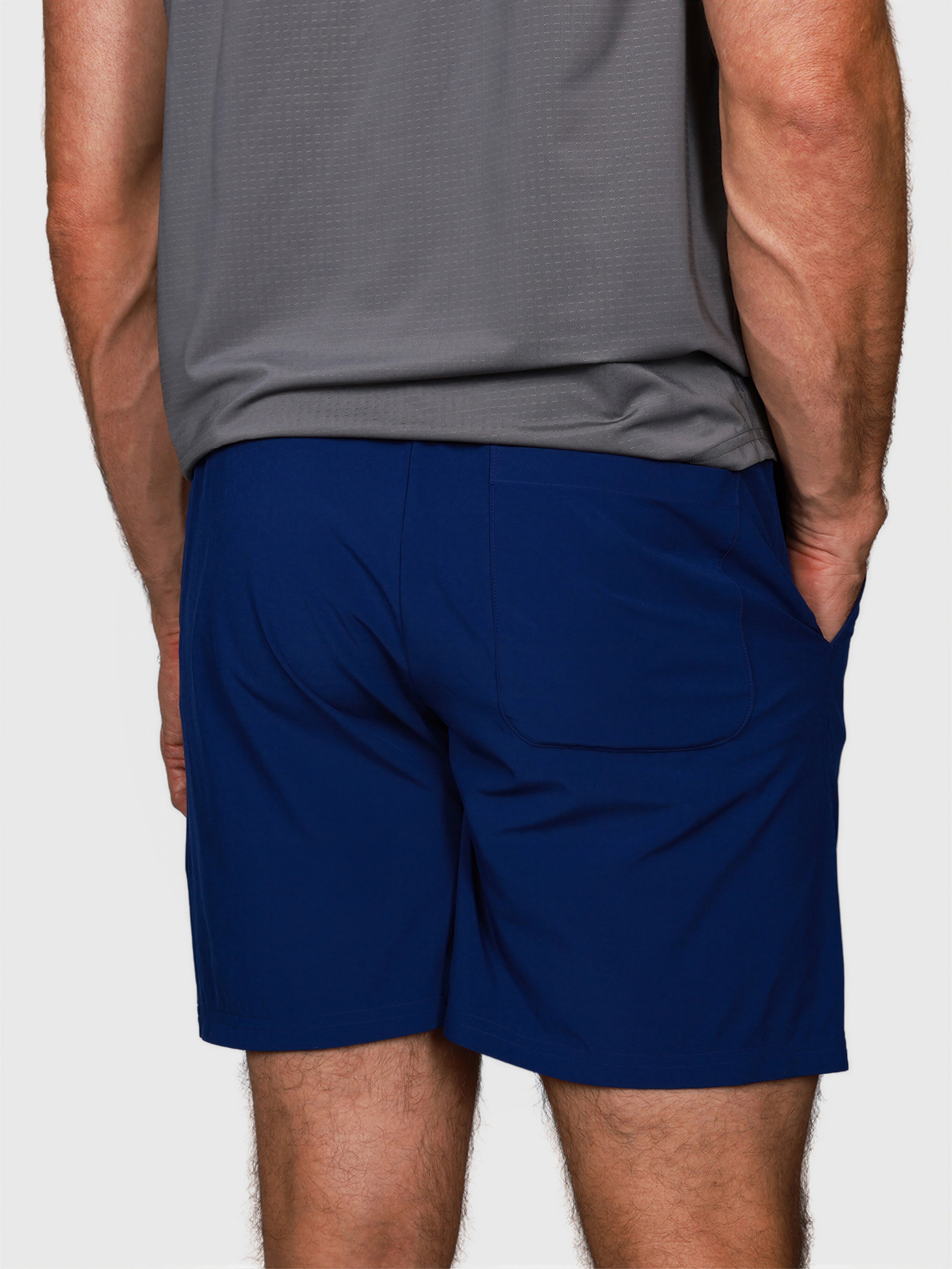 man wearing navy Kick It Short by MUEV with back pockets designed for padel and pickleball apparel