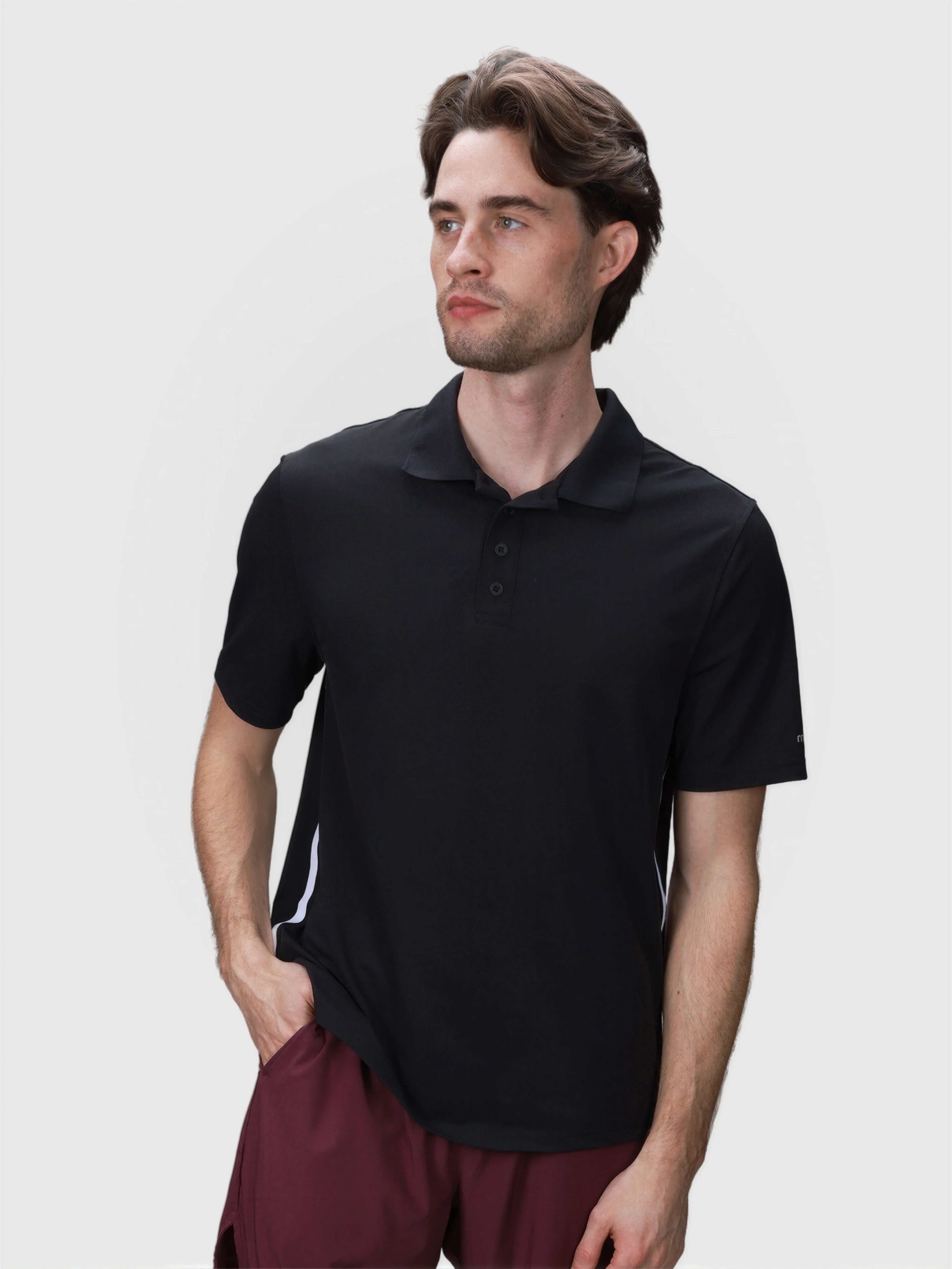Man wearing black Tip Polo by MUEV with short sleeves and classic collar for padel and pickleball apparel
